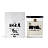 Imperial Barber Grade Products scented candle in a clear glass with a wood wick, shown beside its white cylindrical gift box marked 100% American Made.