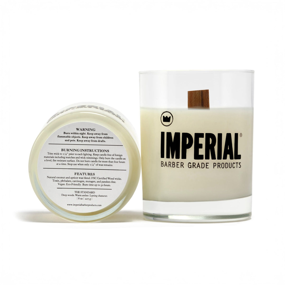 Imperial Barber Grade Products scented candle in a clear glass with a wood wick, shown alongside its lid displaying warning and ingredient information.