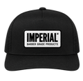 Front view of a black Imperial Barber Grade Products trucker hat with a rectangular woven patch bearing the Imperial Barber Grade Products logo in black on white.