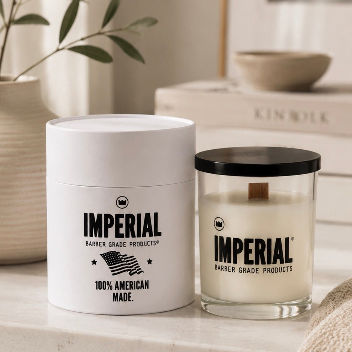 Imperial Barber Grade Products Standard Candle in a clear glass jar with a wood wick beside its white cylindrical tube, labelled 100% American Made.