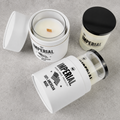 Three Imperial Barber Grade Products Standard Candles on a concrete surface, one open showing the wood wick, one capped in black, and one tipped on its side showing the 100% American Made label.