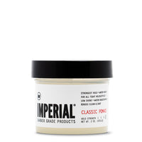 Front view of the Imperial Classic Pomade 2 oz travel-size tub with black lid, showing strongest-hold, water-based formula label.