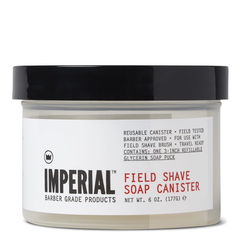Angled front view of Imperial Field Shave Soap Canister, 6 oz clear jar with black lid, labelled reusable canister containing one 3-inch refillable glycerin soap puck.