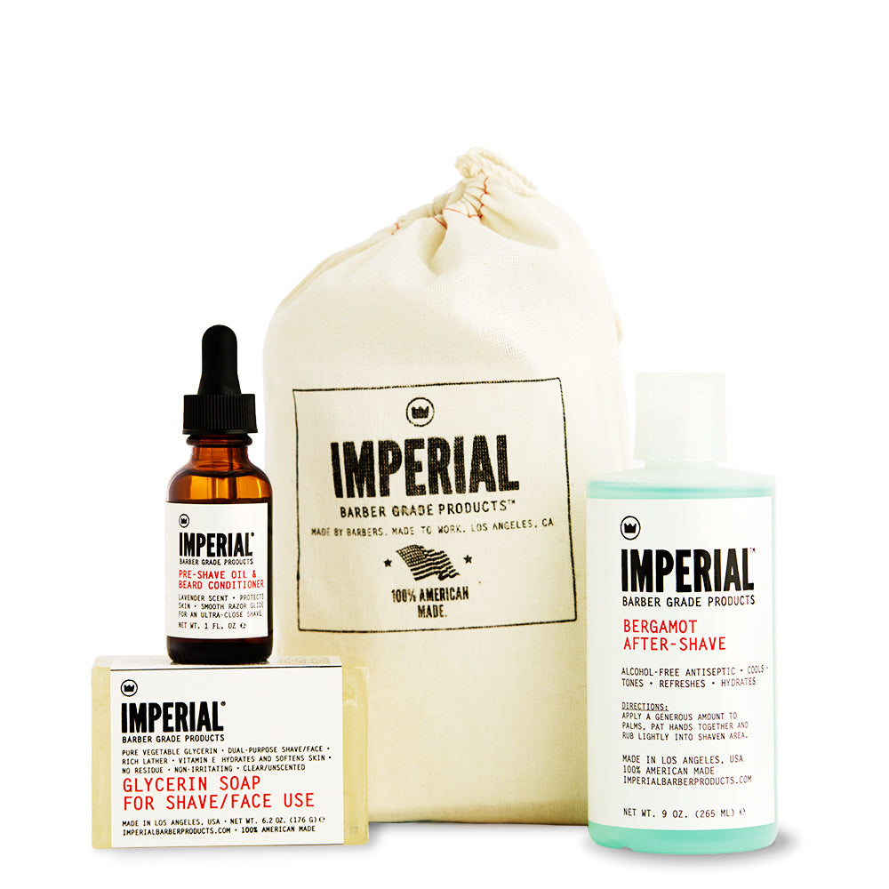 Imperial Barber shave bundle laid out with a Pre-Shave Oil and Beard Conditioner dropper bottle, a Glycerin Soap bar, and a Bergamot After-Shave spray, all in front of a branded canvas drawstring bag.