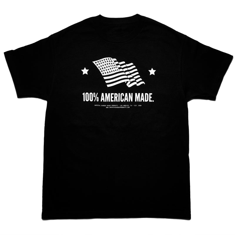 Front of a black Imperial Barber Grade Products t-shirt printed with a waving American flag graphic and the text "100% American Made.".