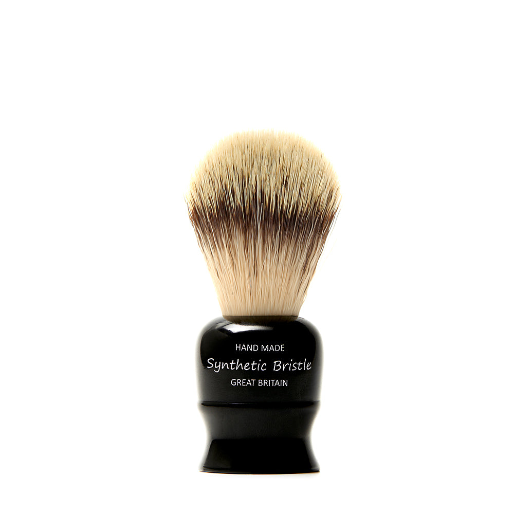 Front view of a handmade synthetic bristle shave brush with a glossy black handle, labelled Hand Made Synthetic Bristle Great Britain.